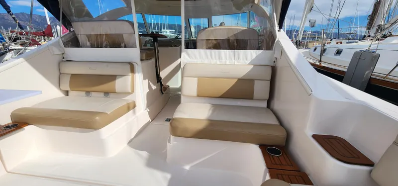 Slide: The Image of 2012 Tiara Yachts 3100 Coronet interior with beige seating and wooden accents. - 22
