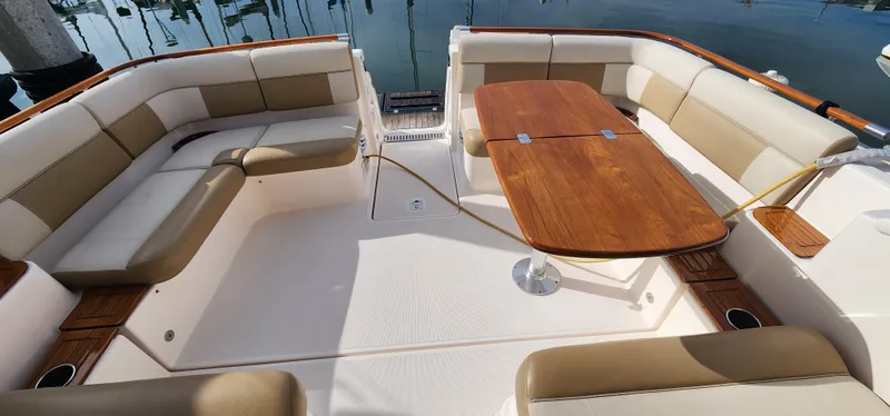Slide: The Image of 2012 Tiara Yachts 3100 Coronet interior with beige seating and wooden table. - 23