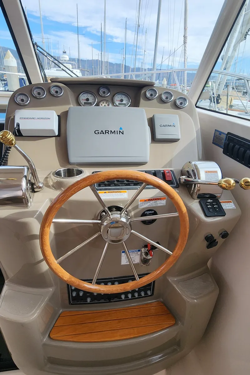 Slide: The Image of 2012 Tiara Yachts 3100 Coronet helm with Garmin navigation and wooden steering wheel. - 3