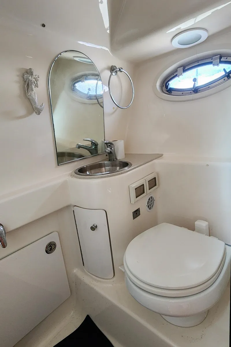 Slide: The Image of 2012 Tiara Yachts 3100 Coronet bathroom with sink, mirror, and porthole window. - 30