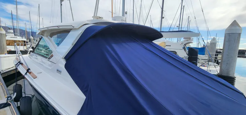 Slide: The Image of 2012 Tiara Yachts 3100 Coronet with blue cover docked at marina. - 35