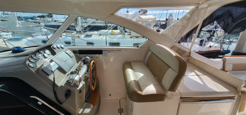 Slide: The Image of 2012 Tiara Yachts 3100 Coronet cockpit with steering wheel, controls, and seating, docked at marina. - 6