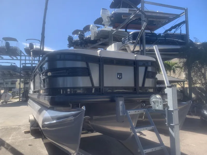 Slide: The Image of 2025 Godfrey San Pan 2700 DFLW pontoon boat on trailer, displayed outdoors. - 3