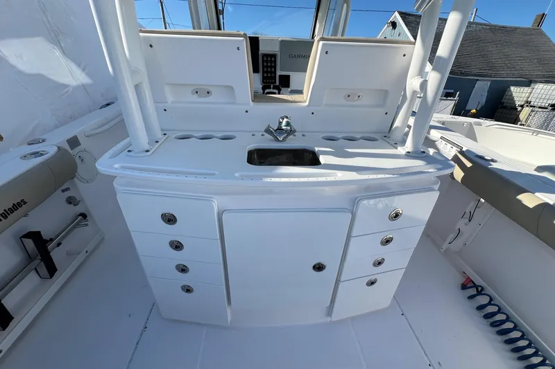 Slide: The Image of 2014 Everglades 325 Center Console boat interior with beige seating on calm water. - 12