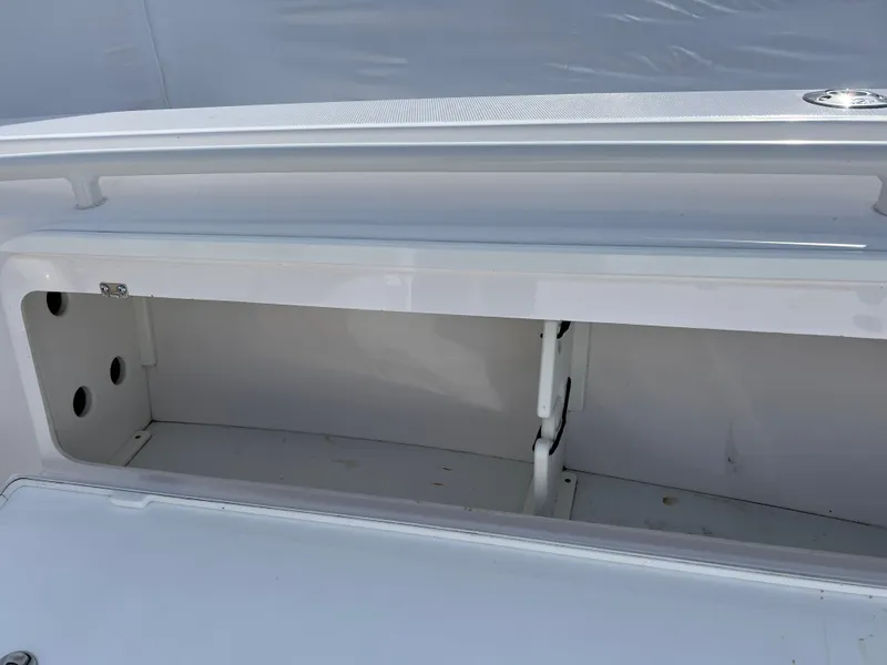 Slide: The Image of 2014 Everglades 325 Center Console boat with beige seating, docked by a calm waterfront. - 13