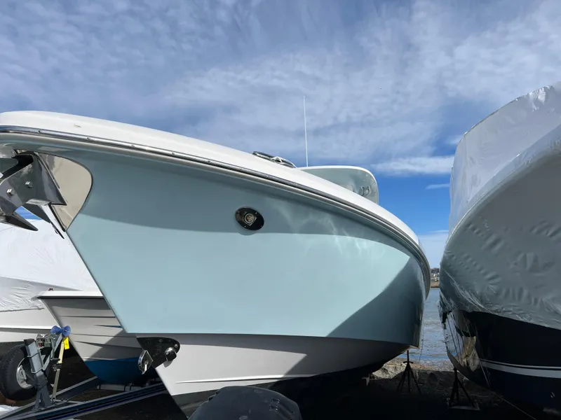 Slide: The Image of 2014 Everglades 325 Center Console boat on water, cloudy sky background. - 2