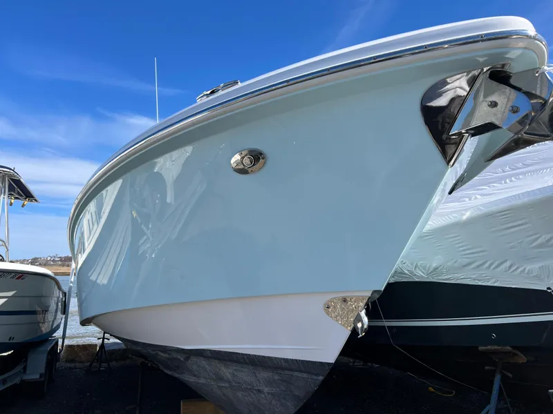Slide: The Image of 2014 Everglades 325 Center Console boat on calm water, surrounded by lush greenery. - 3