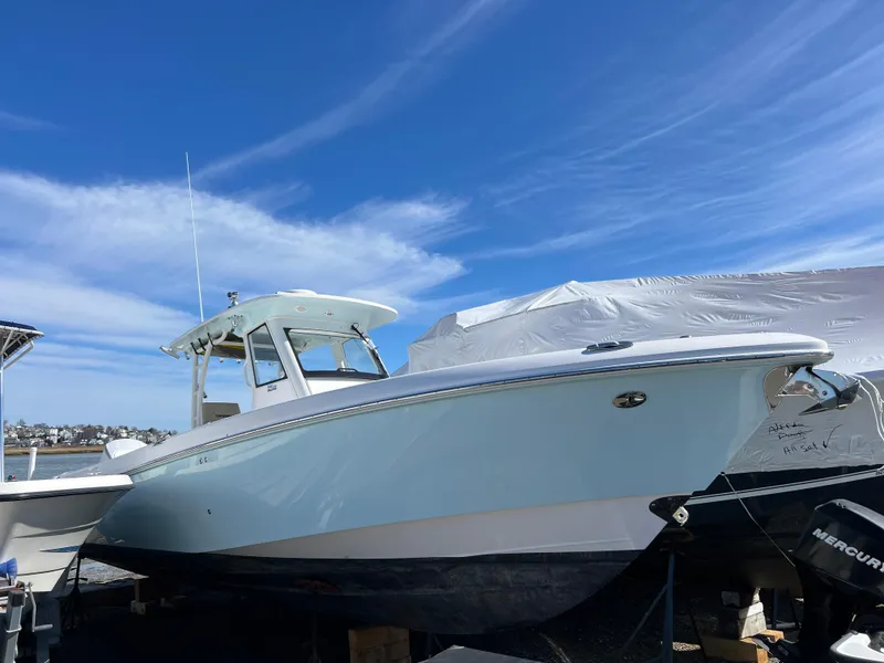 Slide: The Image of 2014 Everglades 325 Center Console boat on water under cloudy sky. - 4