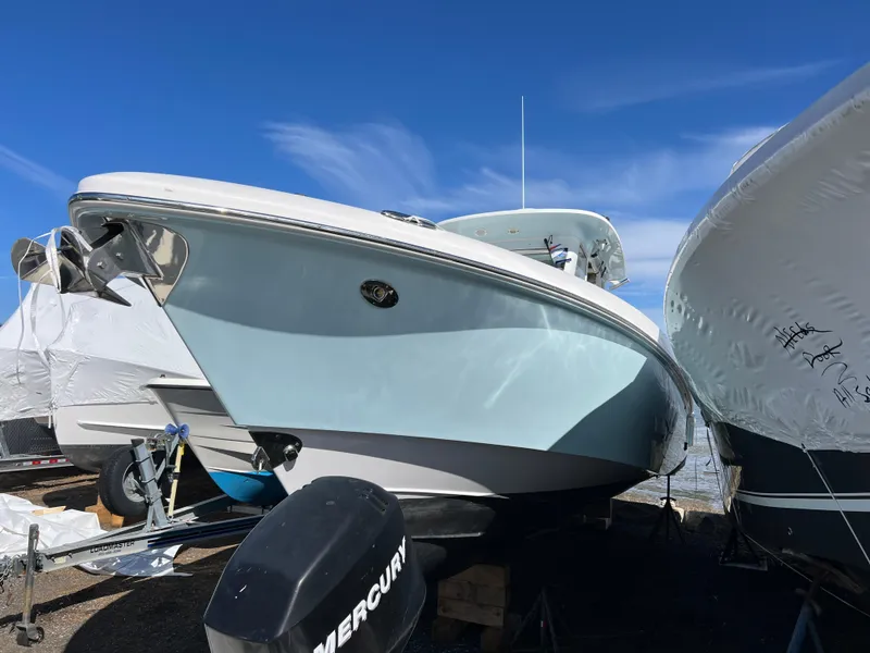 Slide: The Image of 2014 Everglades 325 Center Console boat on calm water, under a partly cloudy sky. - 5