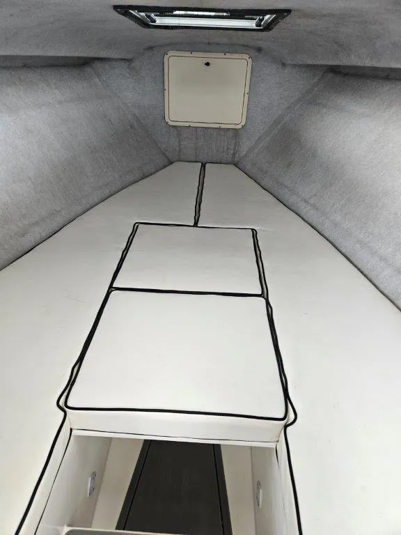 Slide: The Image of 1993 Marlin Yachts Cuddy SF interior cabin with white cushioned seating. - 11