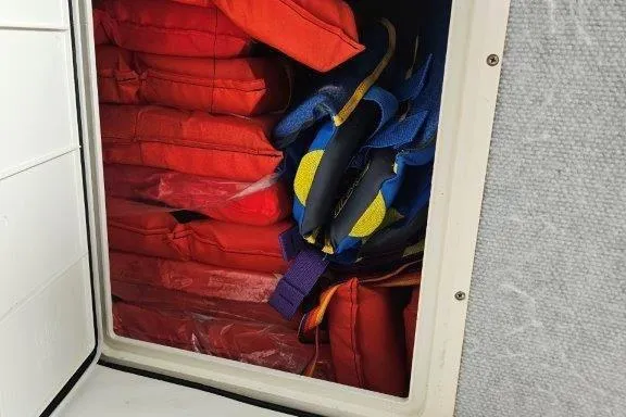 Slide: The Image of Storage compartment with red life jackets on a 1993 Marlin Yachts Cuddy SF. - 13