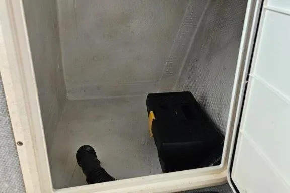 Slide: The Image of Storage compartment of 1993 Marlin Yachts Cuddy SF with black toolbox inside. - 14
