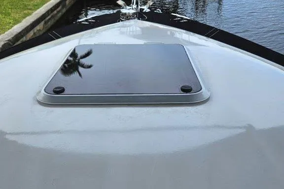 Slide: The Image of 1993 Marlin Yachts Cuddy SF boat deck with hatch, docked by the water. - 16
