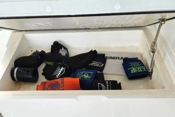 Slide: The Image of Storage compartment on 1993 Marlin Yachts Cuddy SF with assorted beverage koozies. - 17