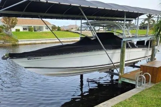 Slide: The Image of 1993 Marlin Yachts Cuddy SF boat docked under a canopy on a calm canal. - 2