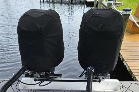 Slide: The Image of Twin covered outboard motors on a 1993 Marlin Yachts Cuddy SF at a dock. - 25