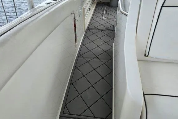 Slide: The Image of 1993 Marlin Yachts Cuddy SF interior with cushioned seating and diamond-patterned flooring. - 7