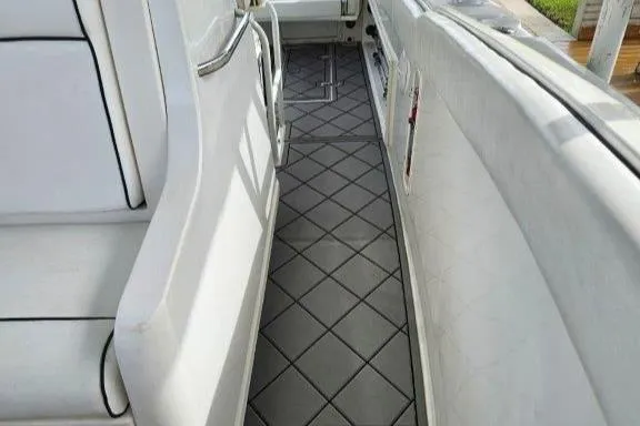 Slide: The Image of 1993 Marlin Yachts Cuddy SF interior with cushioned seating and diamond-patterned flooring. - 8