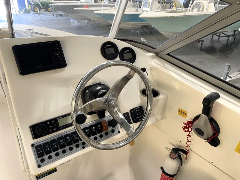 Slide: The Image of 2023 Key West 239 DFS boat dashboard with steering wheel and controls. - 23