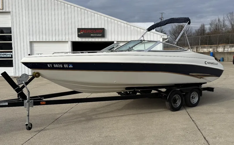The Image of 2001 Caravelle 209 Bow Rider boat on trailer, parked outside a building. - 1