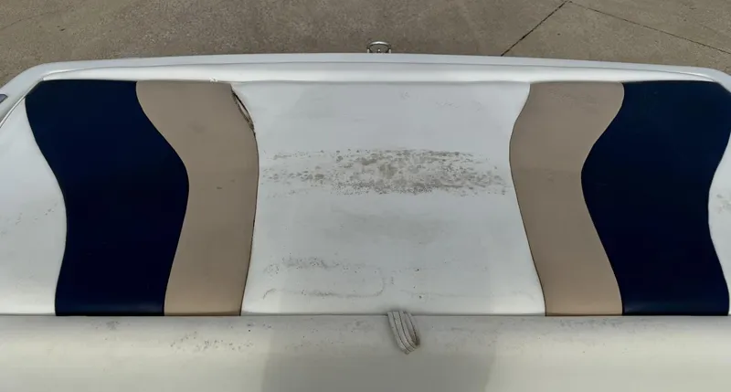 Slide: The Image of 2001 Caravelle 209 Bow Rider boat seat with blue and beige upholstery, showing signs of wear. - 16