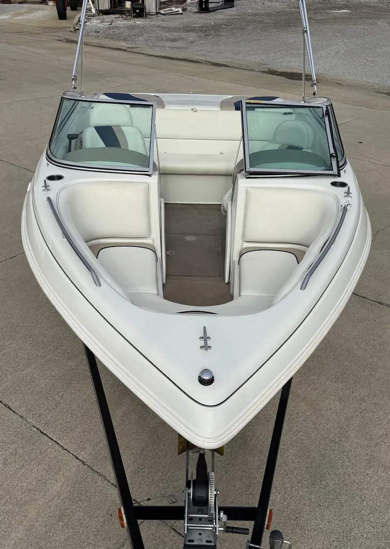 Slide: The Image of 2001 Caravelle 209 Bow Rider boat on trailer, featuring white seating and windshield. - 8