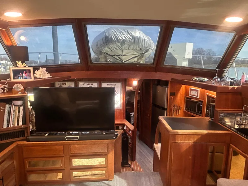 Slide: The Image of Interior of 1985 Viking 50 Cockpit MY yacht with TV, kitchen, and wood paneling. - 11