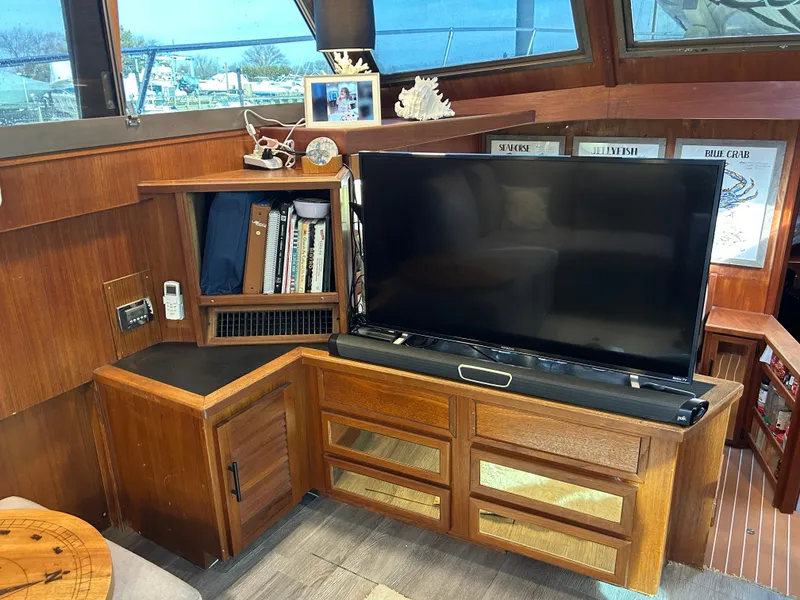 Slide: The Image of 1985 Viking 50 Cockpit MY interior with TV, wooden cabinets, and nautical decor. - 13