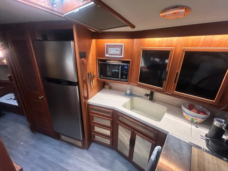 Slide: The Image of 1985 Viking 50 Cockpit MY kitchen with wood cabinets, stainless steel fridge, and modern appliances. - 16