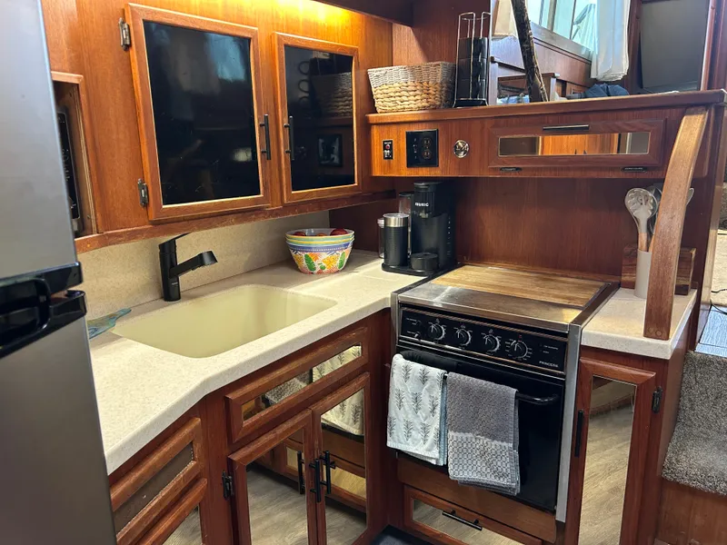 Slide: The Image of 1985 Viking 50 Cockpit MY kitchen with wooden cabinets, stove, and sink. - 17