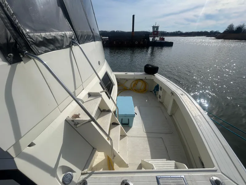Slide: The Image of 1985 Viking 50 Cockpit MY yacht docked, featuring spacious deck and scenic water view. - 2