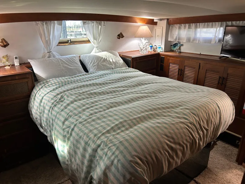 Slide: The Image of Cozy bedroom interior of 1985 Viking 50 Cockpit MY yacht with striped bedding. - 25