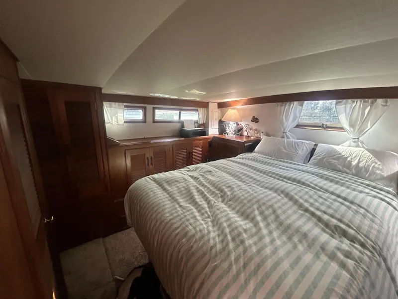 Slide: The Image of Cozy bedroom in 1985 Viking 50 Cockpit MY yacht with striped bedding and wooden cabinetry. - 26