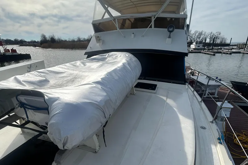 Slide: The Image of 1985 Viking 50 Cockpit MY yacht docked, covered equipment on deck, marina in background. - 33