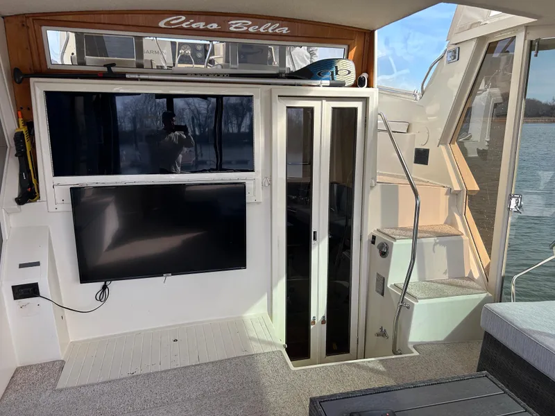 Slide: The Image of 1985 Viking 50 Cockpit MY interior with TV, stairs, and water view. - 4