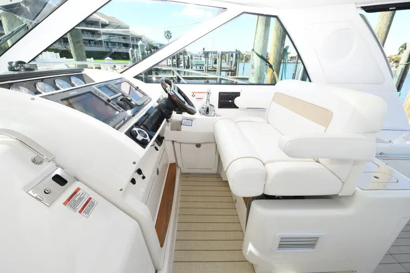 Slide: The Image of 2010 Sea Ray 450 Sundancer helm with white seating and modern controls. - 12