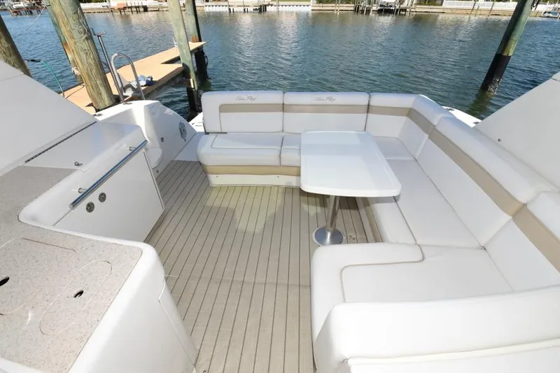 Slide: The Image of 2010 Sea Ray 450 Sundancer yacht with spacious outdoor seating and table. - 25