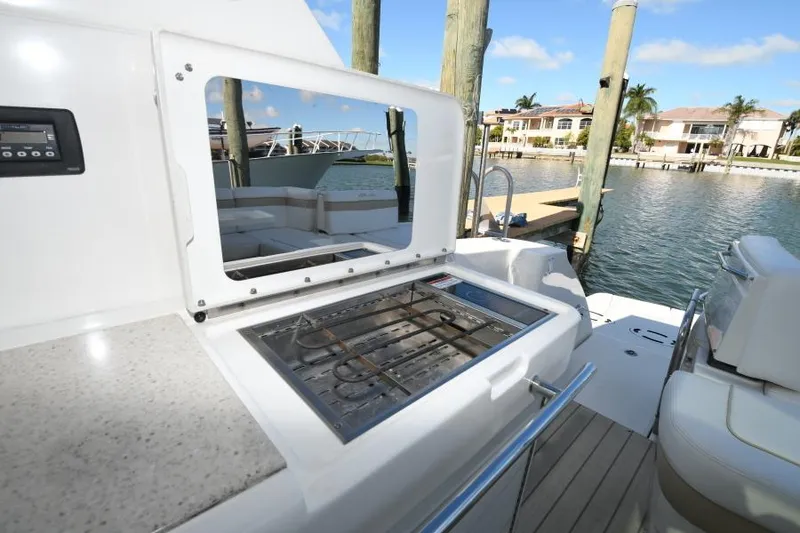 Slide: The Image of 2010 Sea Ray 450 Sundancer yacht with outdoor grill and waterfront view. - 28