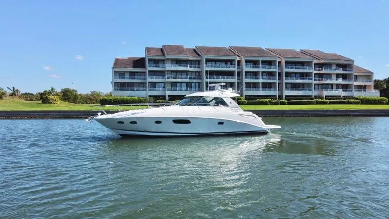 Slide: The Image of 2010 Sea Ray 450 Sundancer yacht cruising near waterfront buildings. - 8