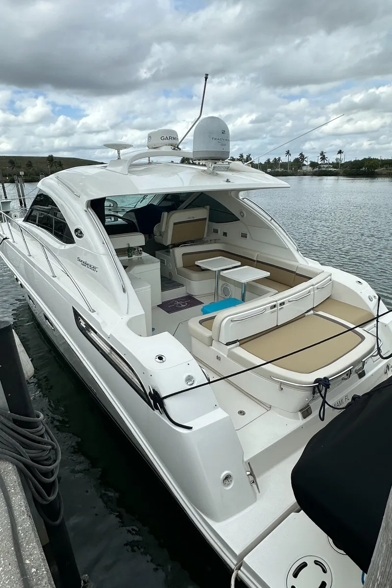 Slide: The Image of 2010 Sea Ray 470 Sundancer yacht docked on a calm waterway under cloudy skies. - 10