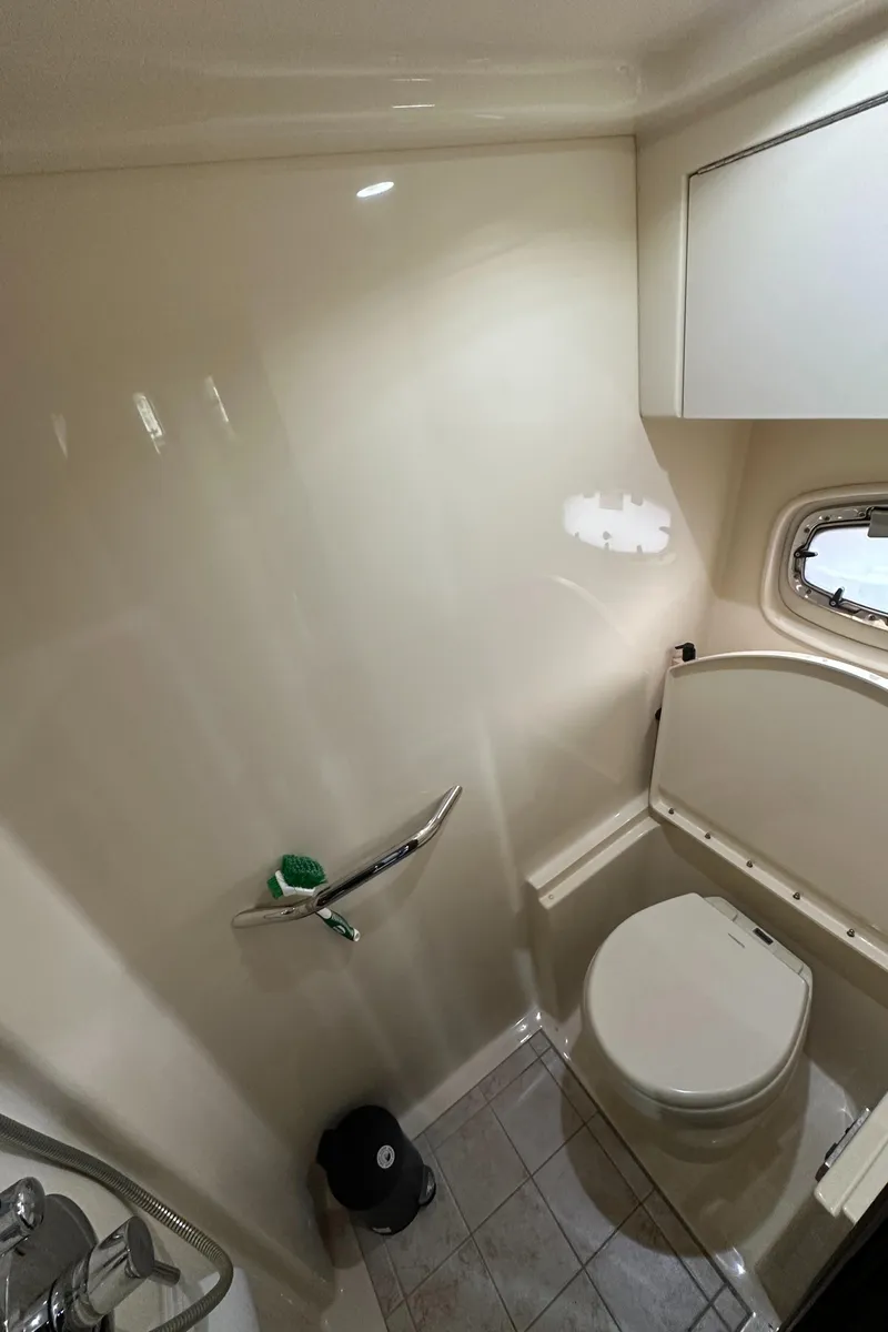 Slide: The Image of Bathroom interior of 2010 Sea Ray 470 Sundancer yacht, featuring compact design and window. - 19