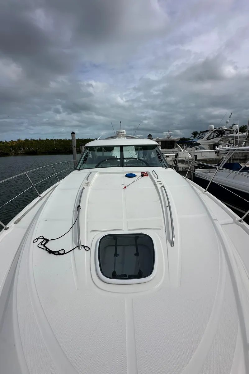 Slide: The Image of 2010 Sea Ray 470 Sundancer yacht docked under cloudy skies. - 28