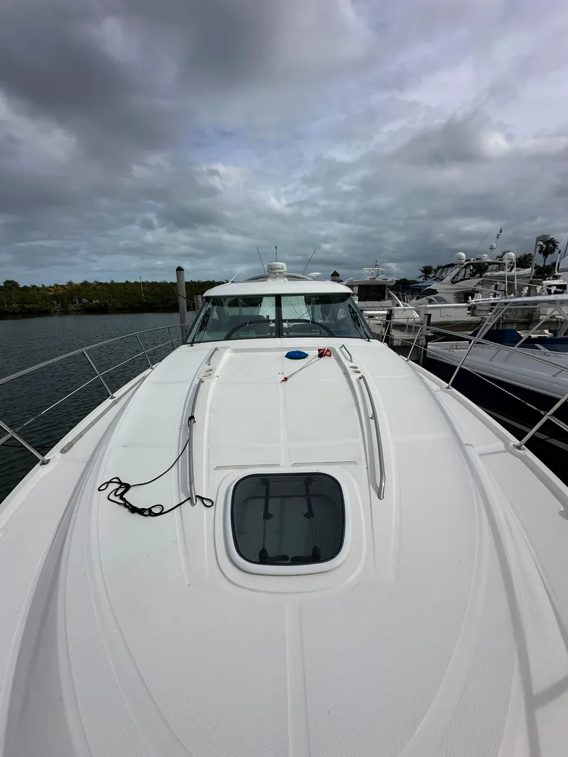 Slide: The Image of 2010 Sea Ray 470 Sundancer yacht, docked under cloudy skies. - 34