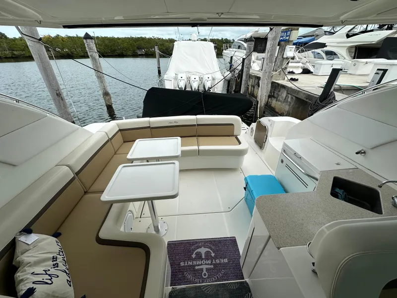 Slide: The Image of 2010 Sea Ray 470 Sundancer yacht interior with seating and tables, docked at marina. - 6
