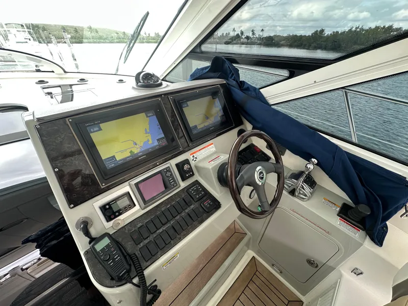 Slide: The Image of Cockpit of 2010 Sea Ray 470 Sundancer with navigation screens and steering wheel. - 9