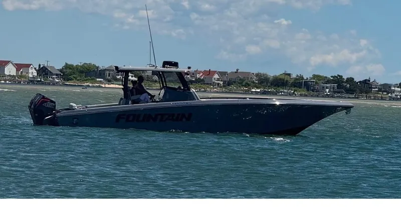 The Image of 2024 Fountain 38 SC boat cruising on a sunny day near the shoreline. - 1