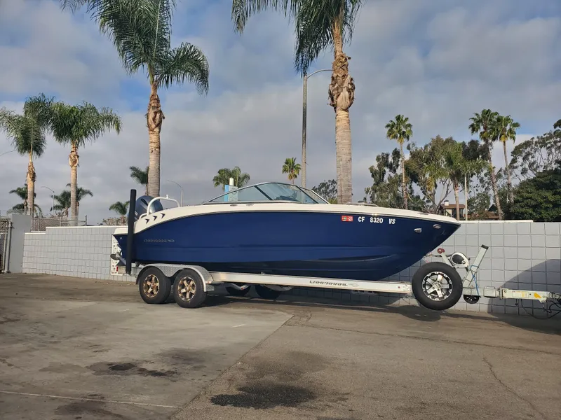 Slide: The Image of 2020 Chaparral 21 SSi OB boat on trailer, parked near palm trees. - 6