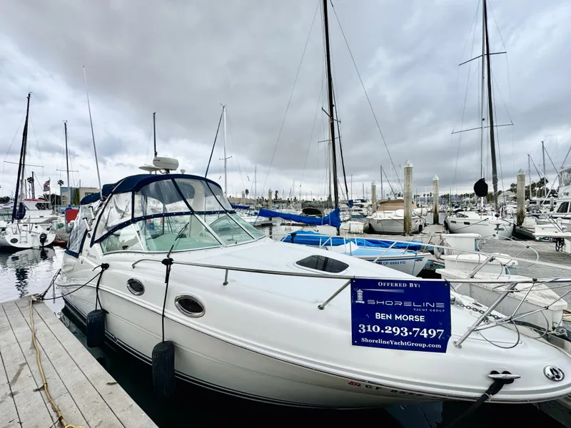 The Image of 2005 Sea Ray Sundancer 260 docked at marina, cloudy sky. - 0