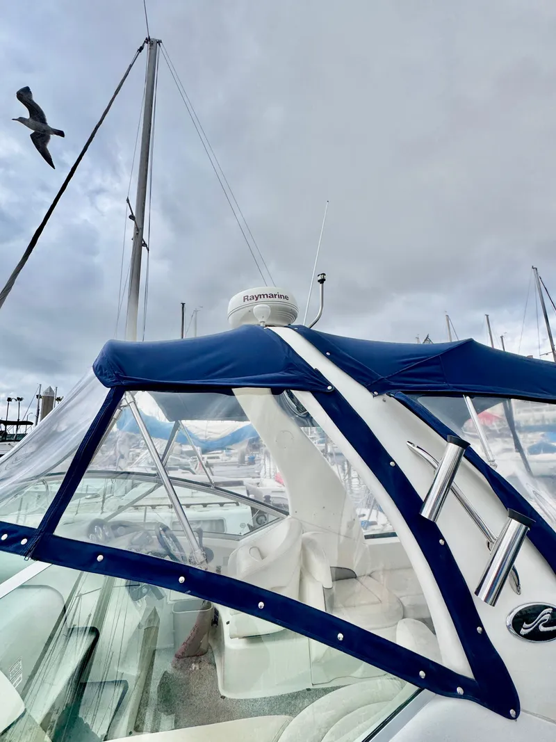 Slide: The Image of 2005 Sea Ray Sundancer 260 with blue canopy in marina. - 3