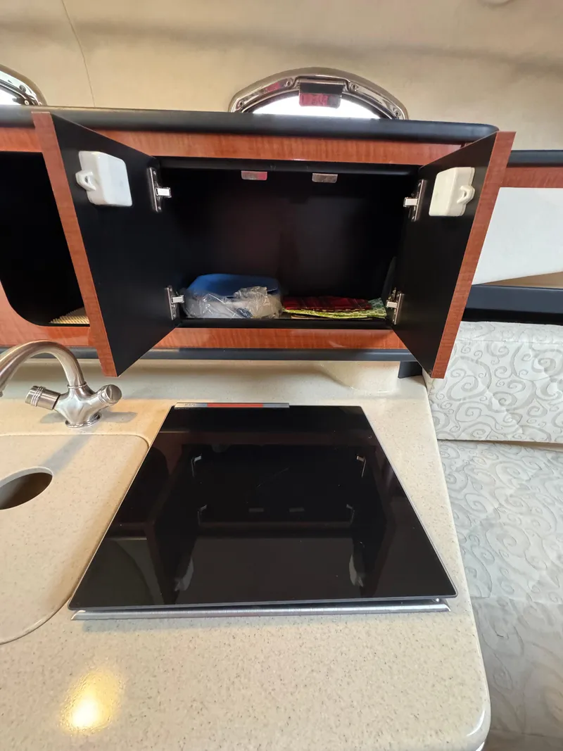 Slide: The Image of 2005 Sea Ray Sundancer 260 kitchen area with stove and cabinet. - 32